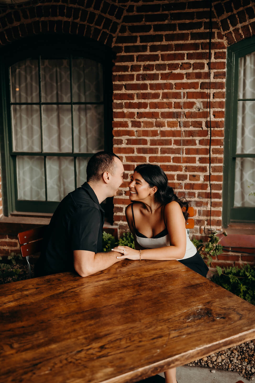 Couple leaning in to each other at a table