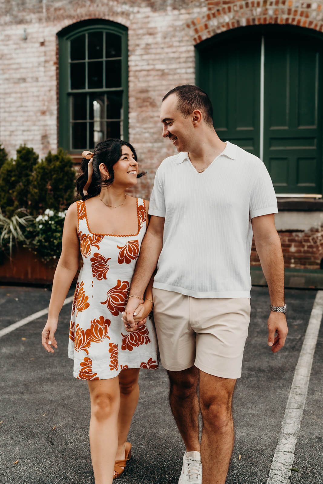 Couple walking and smiling together during their Melrose Knitting Mill Engagement Session