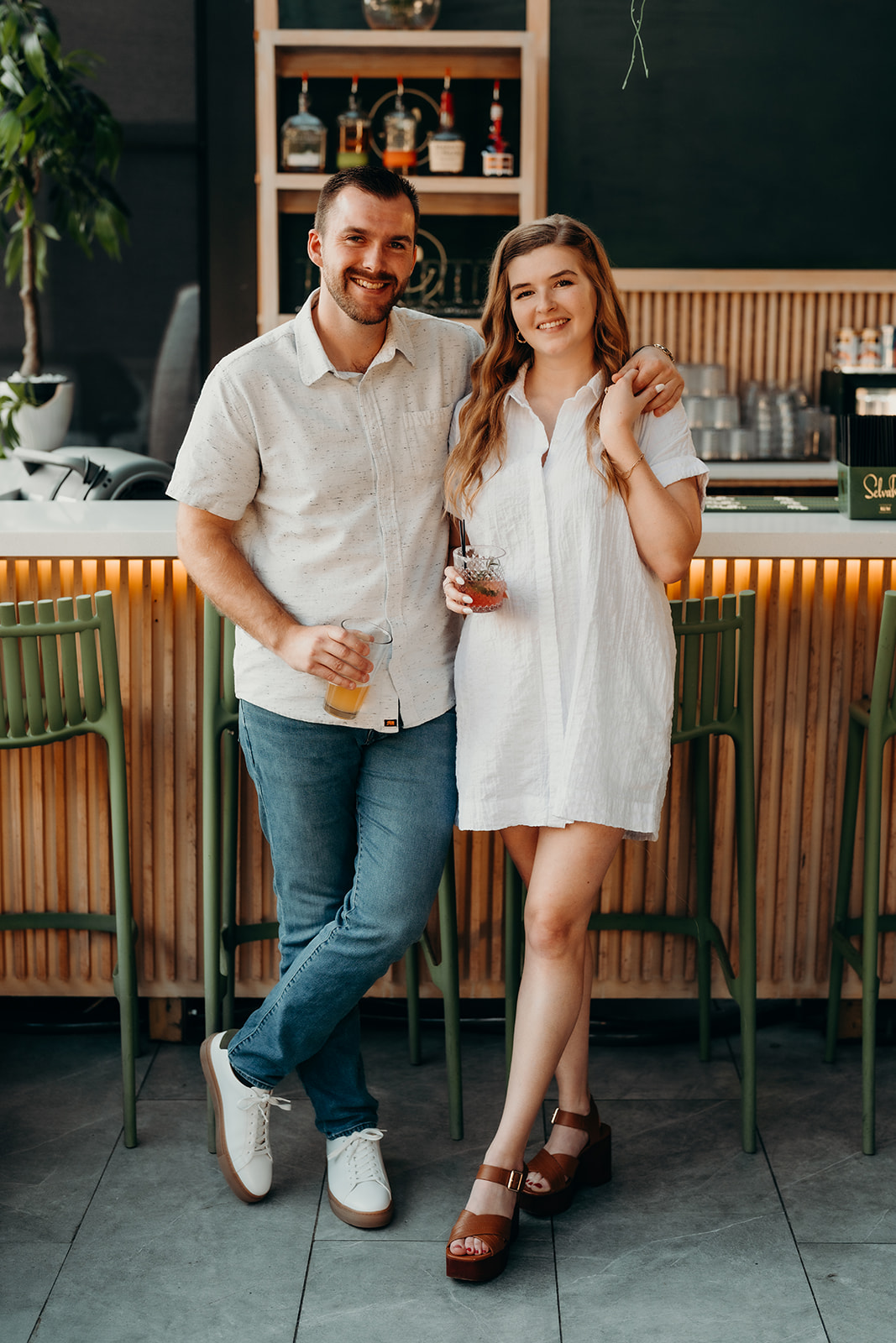 couple posing in front of bar at Must Be Nice in Charlotte