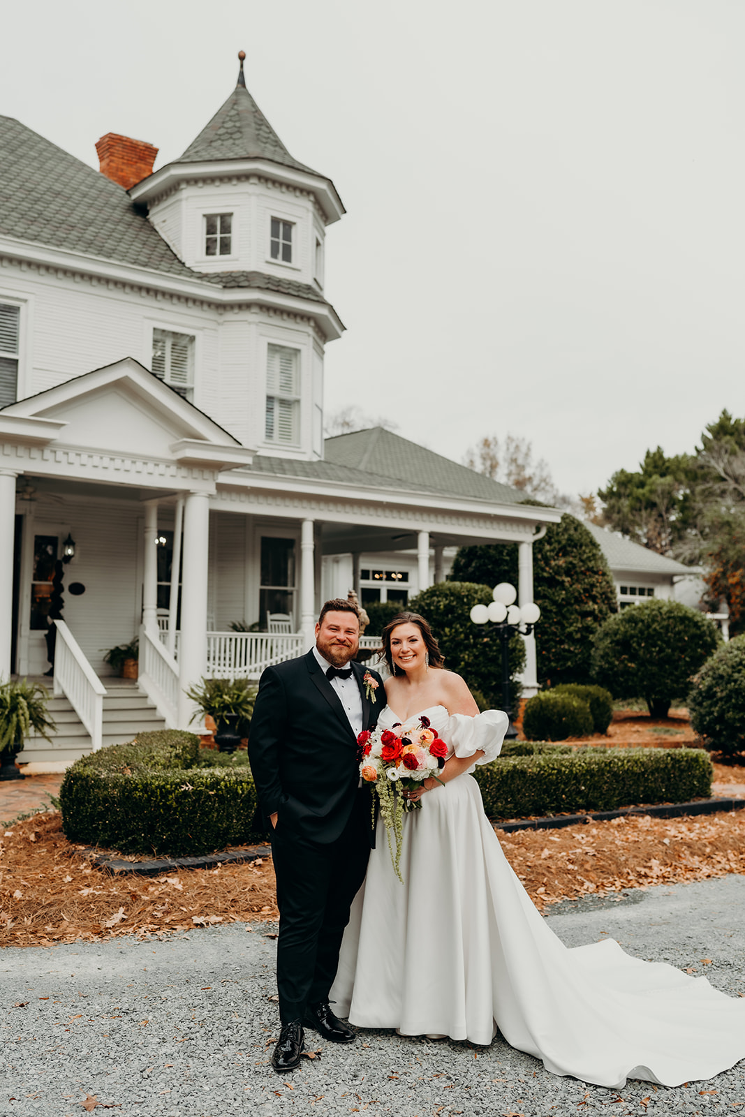 Couple's portraits in front of the grande victorian estate