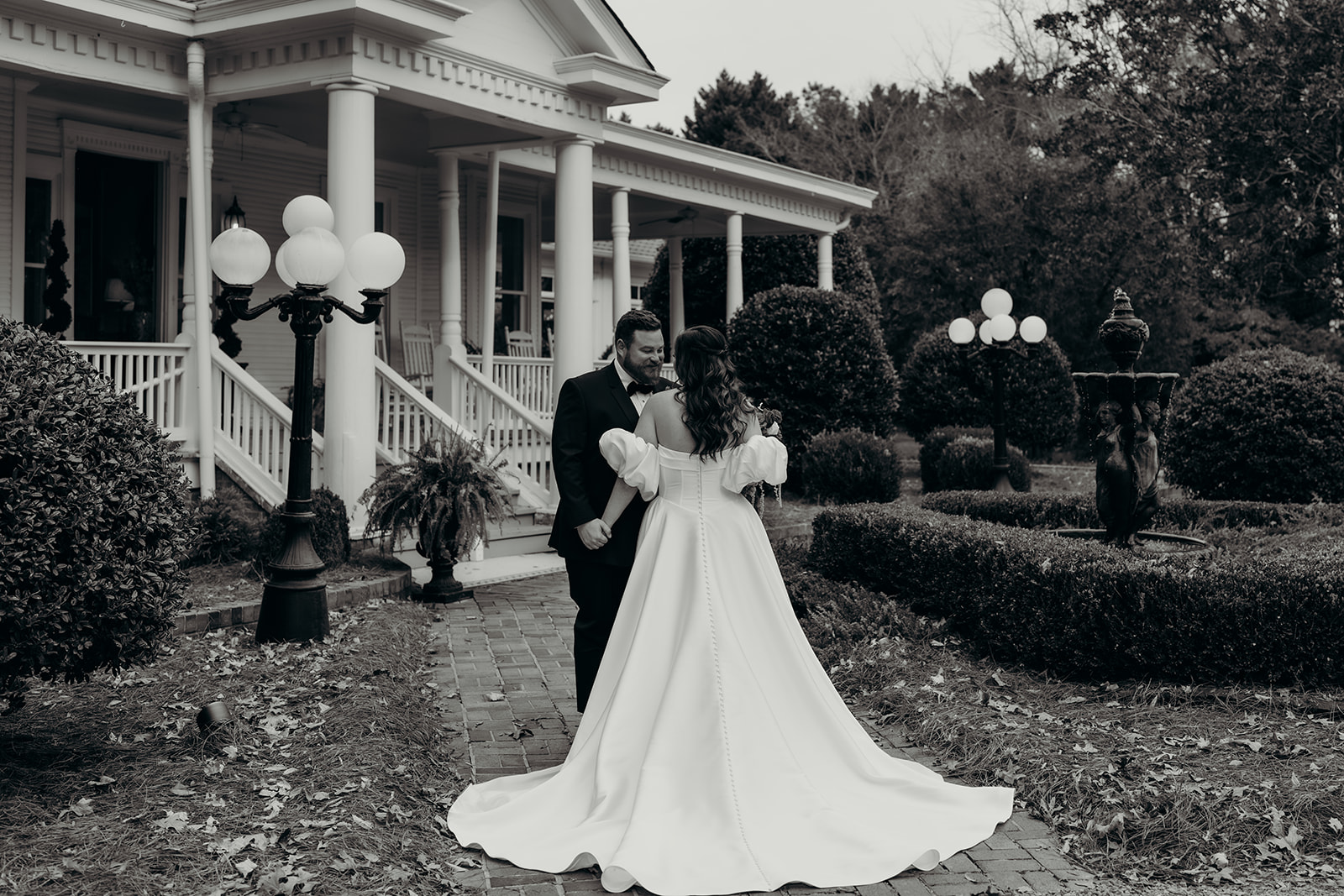 Couple's portraits in front of the grande victorian estate