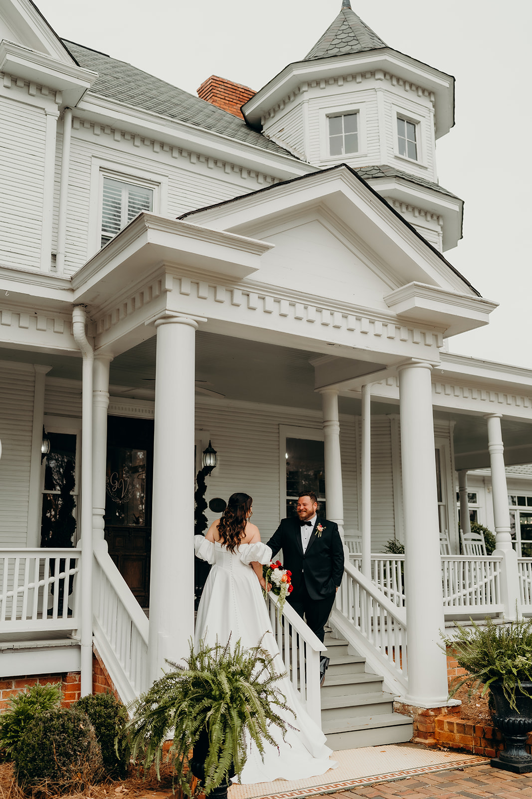 Couple's portraits in front of the grande victorian estate