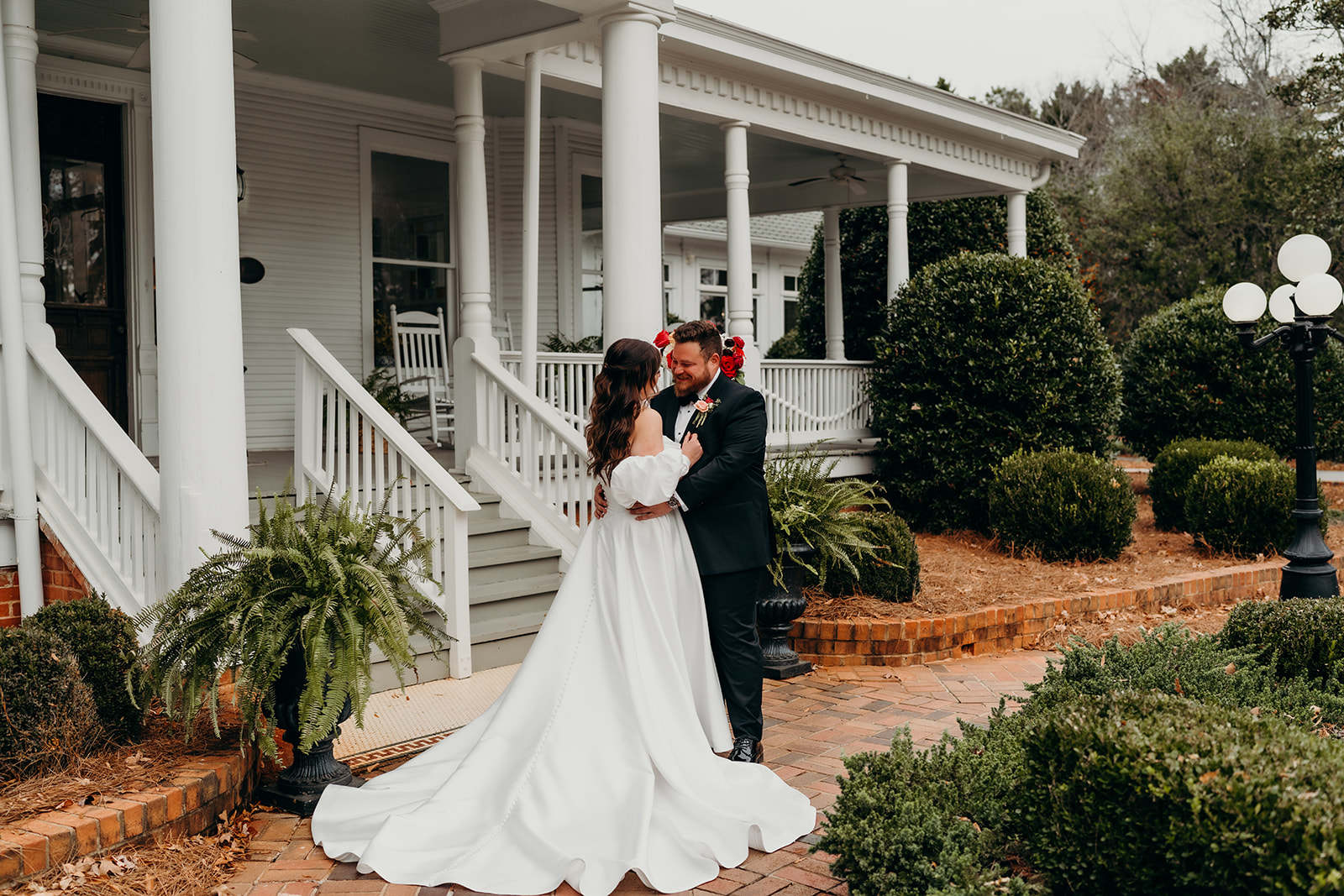 Couple's portraits in front of the grande victorian estate