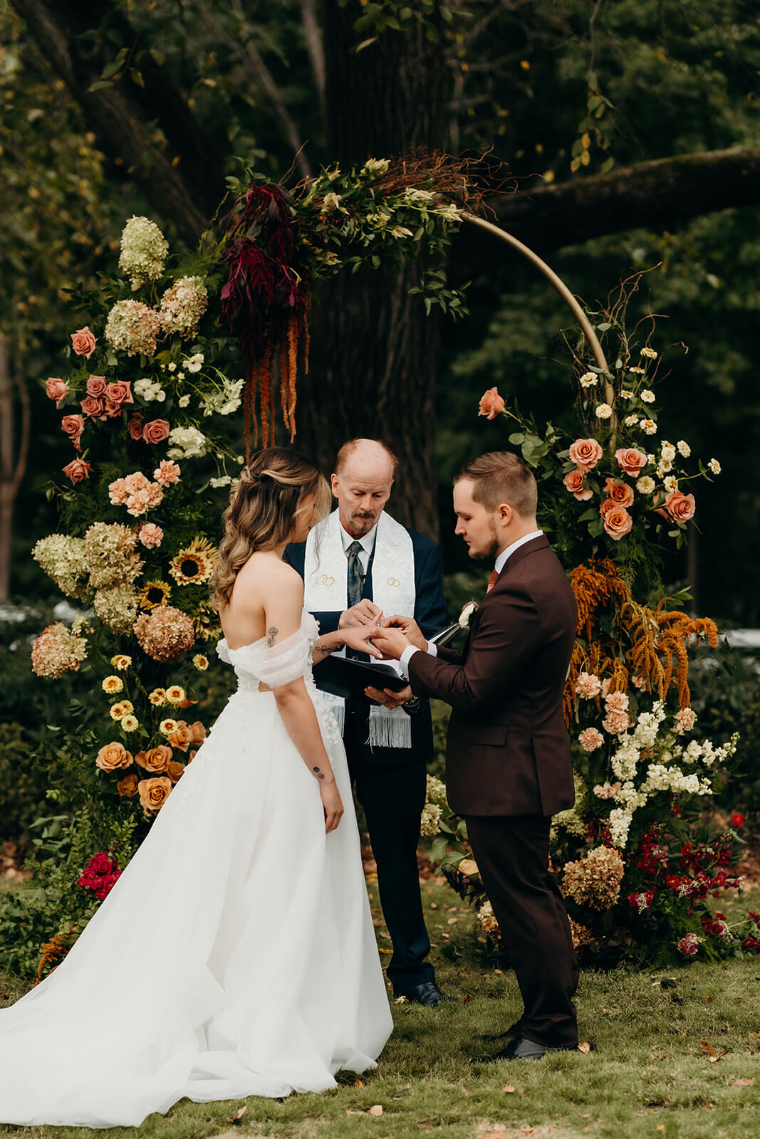 bride and groom exchanging rings at The Historic Wakefield Barn