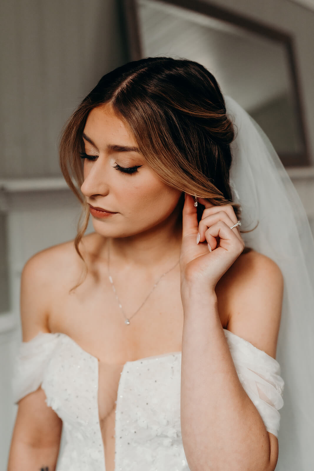 bride adjusting her earring in natural lighting