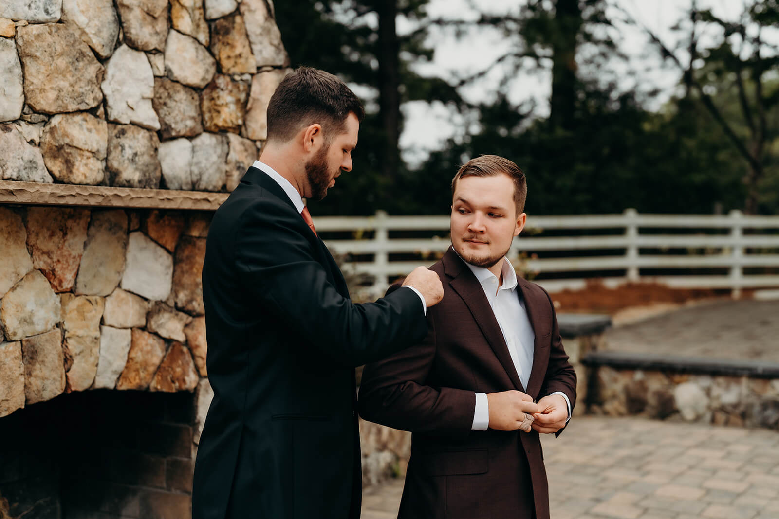 groom getting help putting his suit on