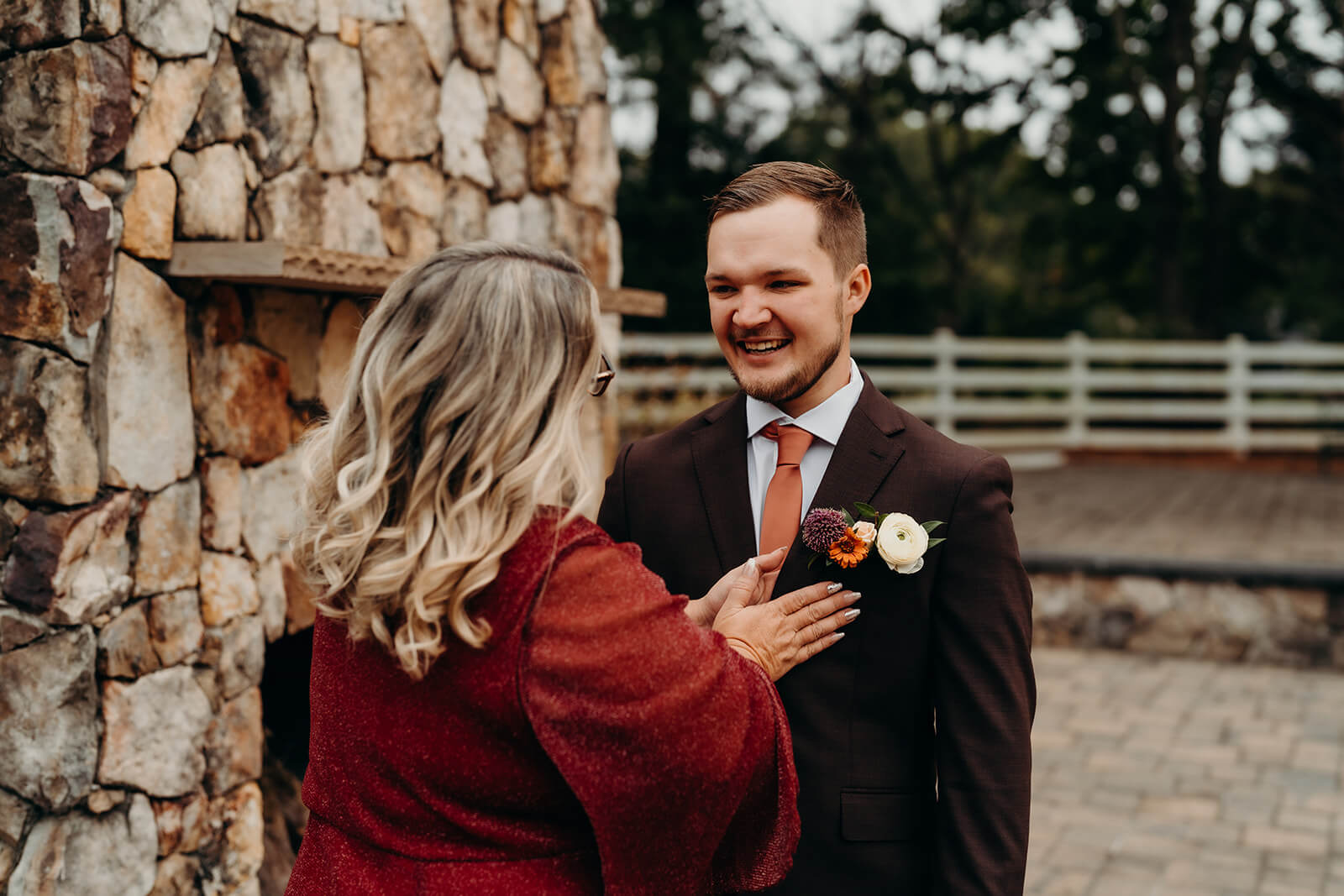 groom's mom helping him get ready