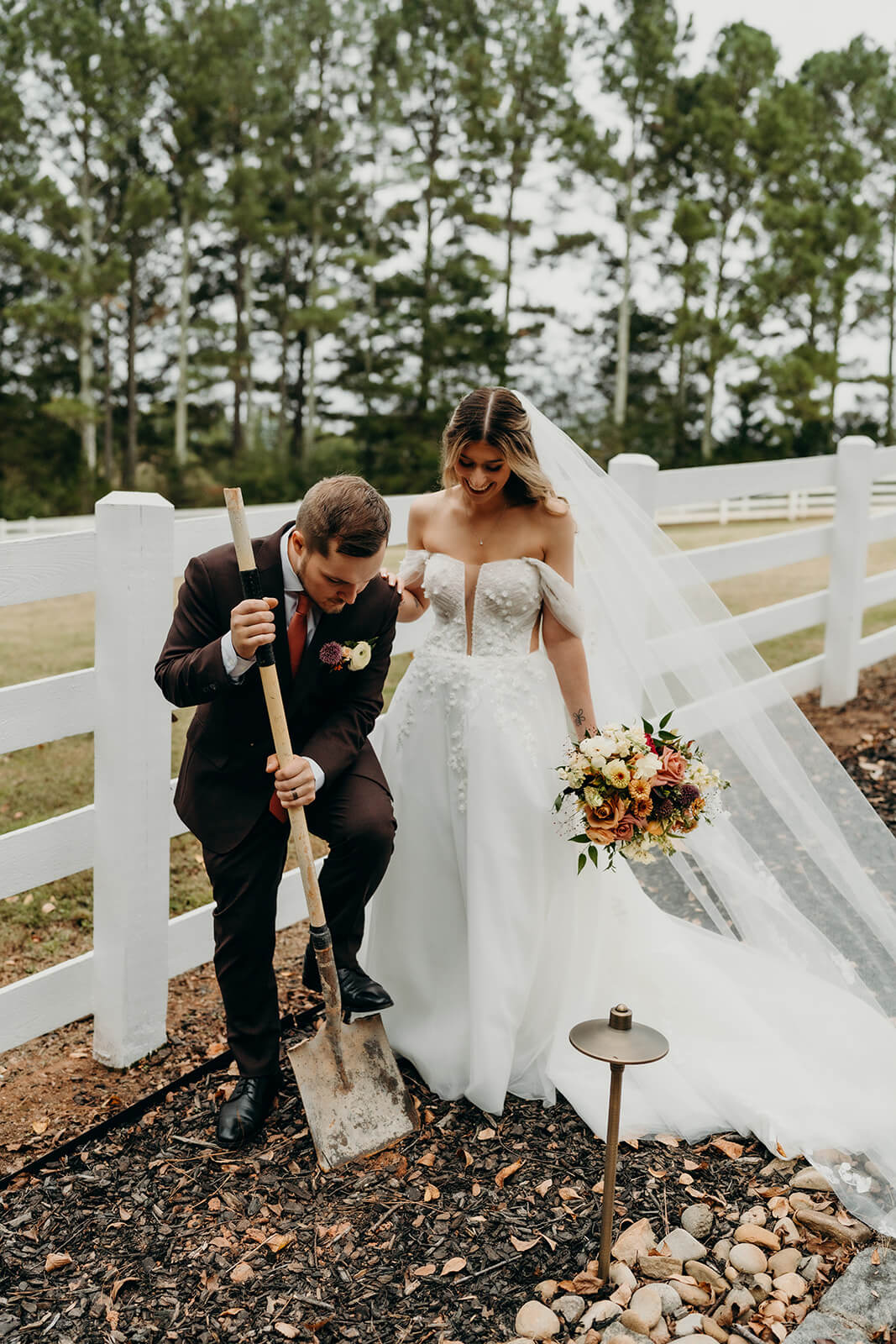 bride and groom digging up the bourbon at bride and groom portraits at The Historic Wakefield Barn
