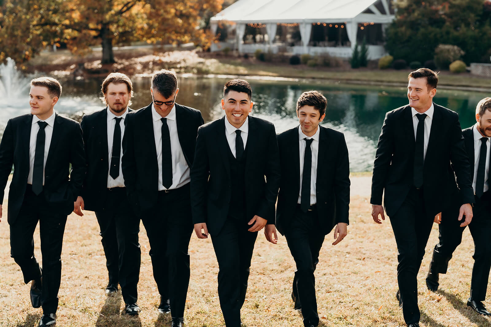 Groomsmen walking in front of the pond at The Oaks at Salem