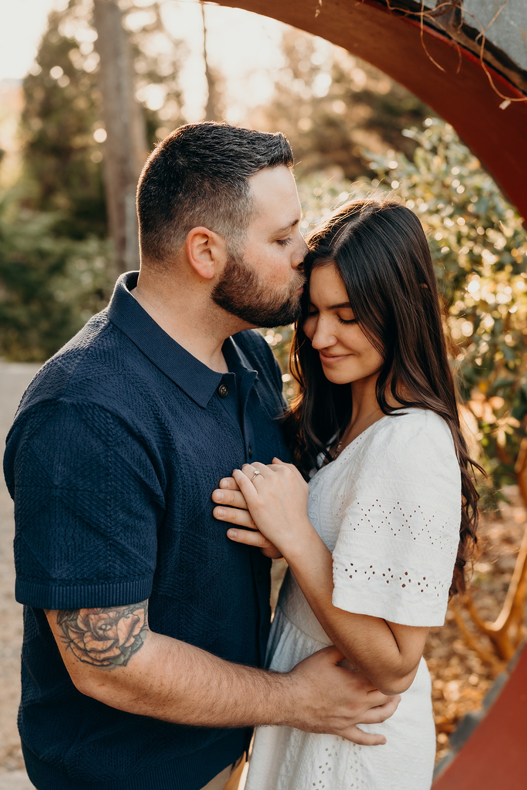 couple holding each other while he kisses her head