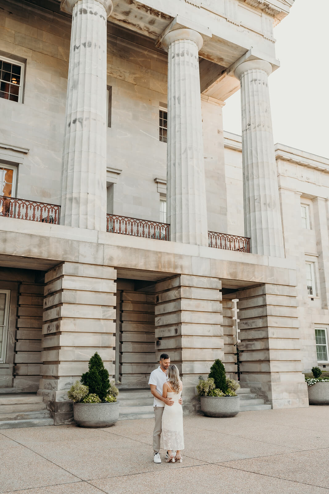 couple standing in front of the capitol building in downtown raleigh