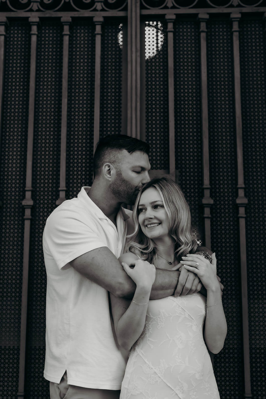 black and white photo of couple where he kisses her forehead downtown raleigh engagement photos