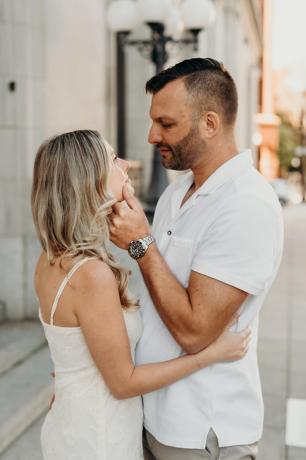 photo of guy holding his fiance's face about to pull her in for a kiss