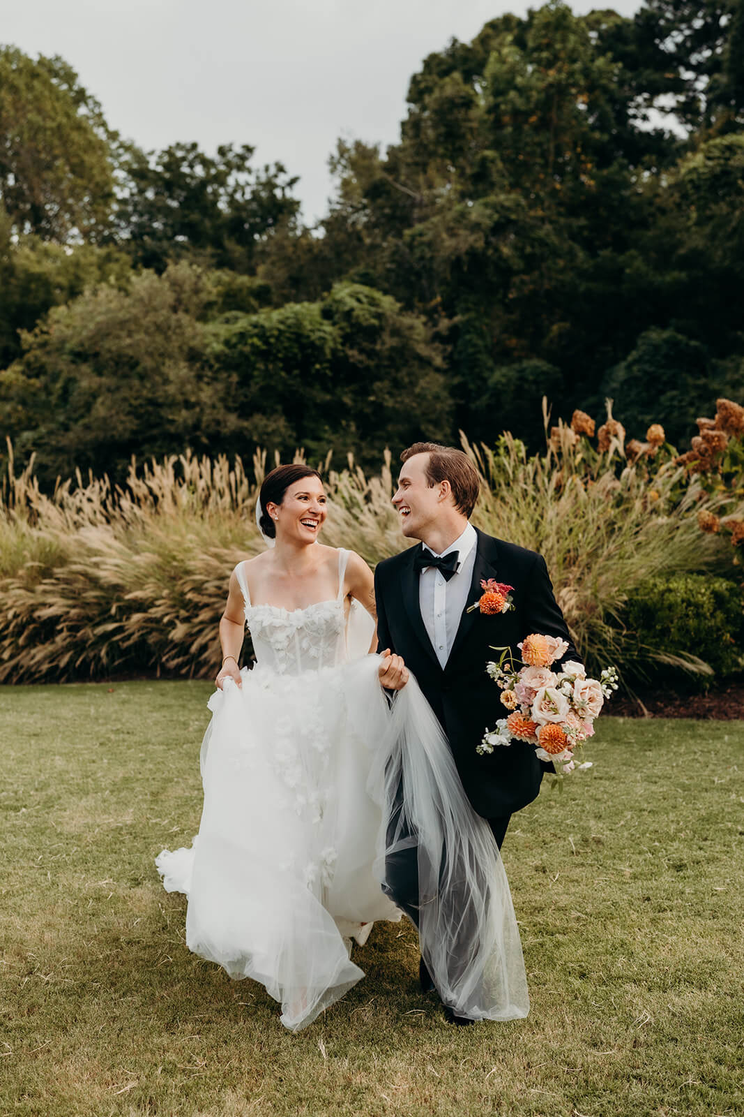 bride and groom running together outside of the maxwell raleigh