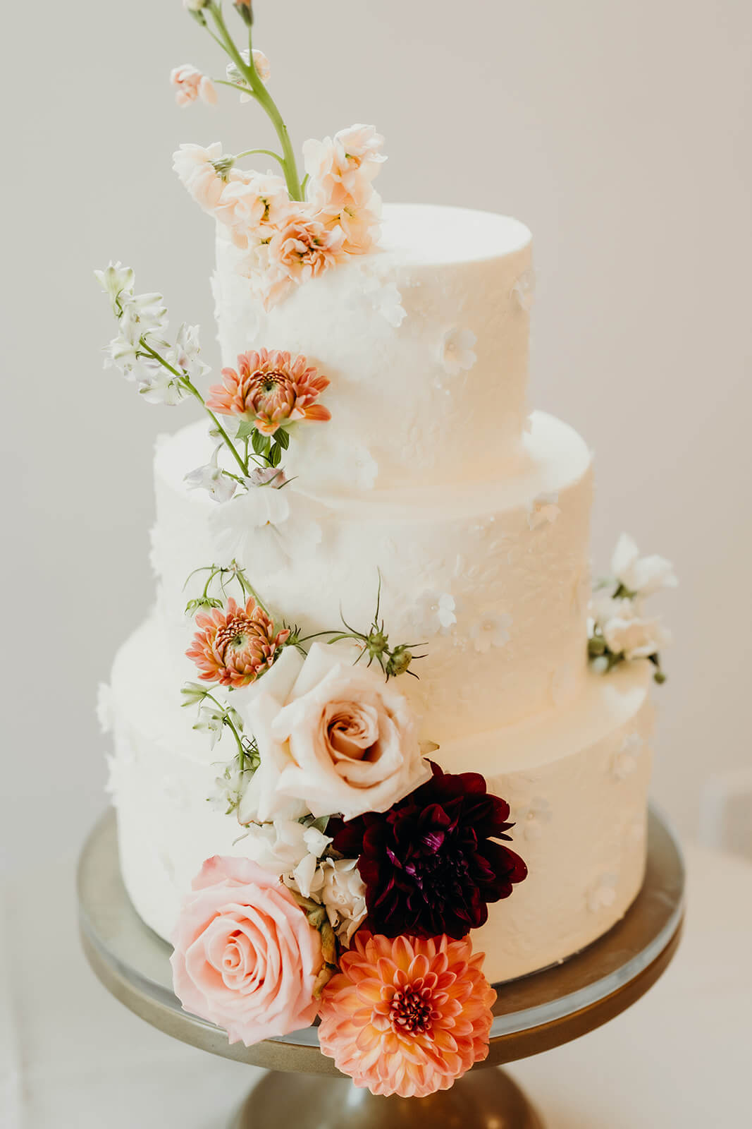 detail shot of the wedding cake with pink and orange flowers
