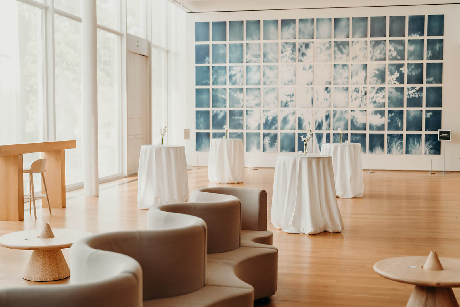 NCMA Wedding Photos of cocktail hour space with white tablecloths and art gallery in the background