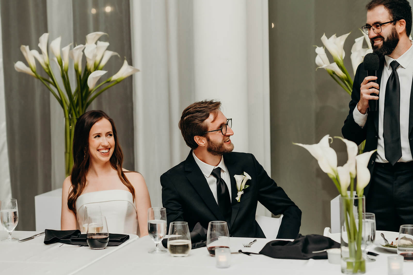 bride and groom laughing while listening to toasts NCMA wedding photos
